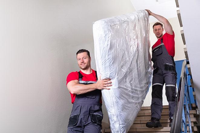 a heavy box spring being carried out of a house in Alameda CA